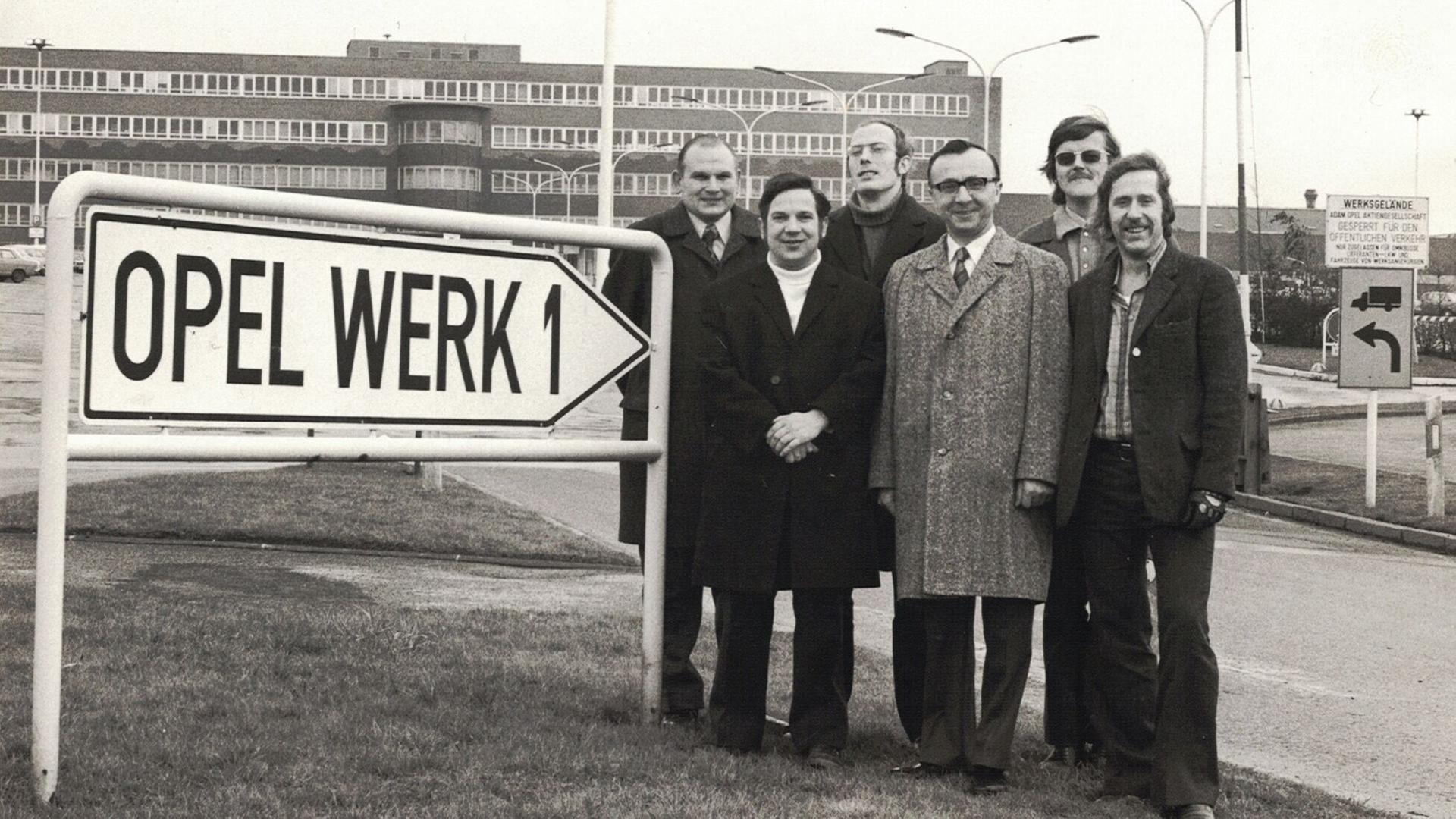 Das alte Foto zeigt sechs Vertreter der Arbeiterschaft von Opel Bochum vor dem Werksgebäude. Links im Bild weist ein Schild auf das Werk hin. Das alte Foto zeigt sechs Vertreter der Arbeiterschaft von Opel Bochum vor dem Werksgebäude. Links im Bild weist ein Schild auf das Werk hin.