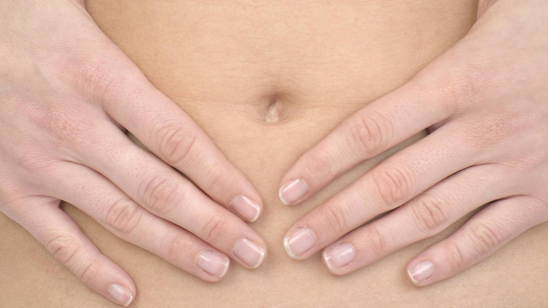 Zwei Hände auf einem Bauch Zwei Hände auf einem Bauch