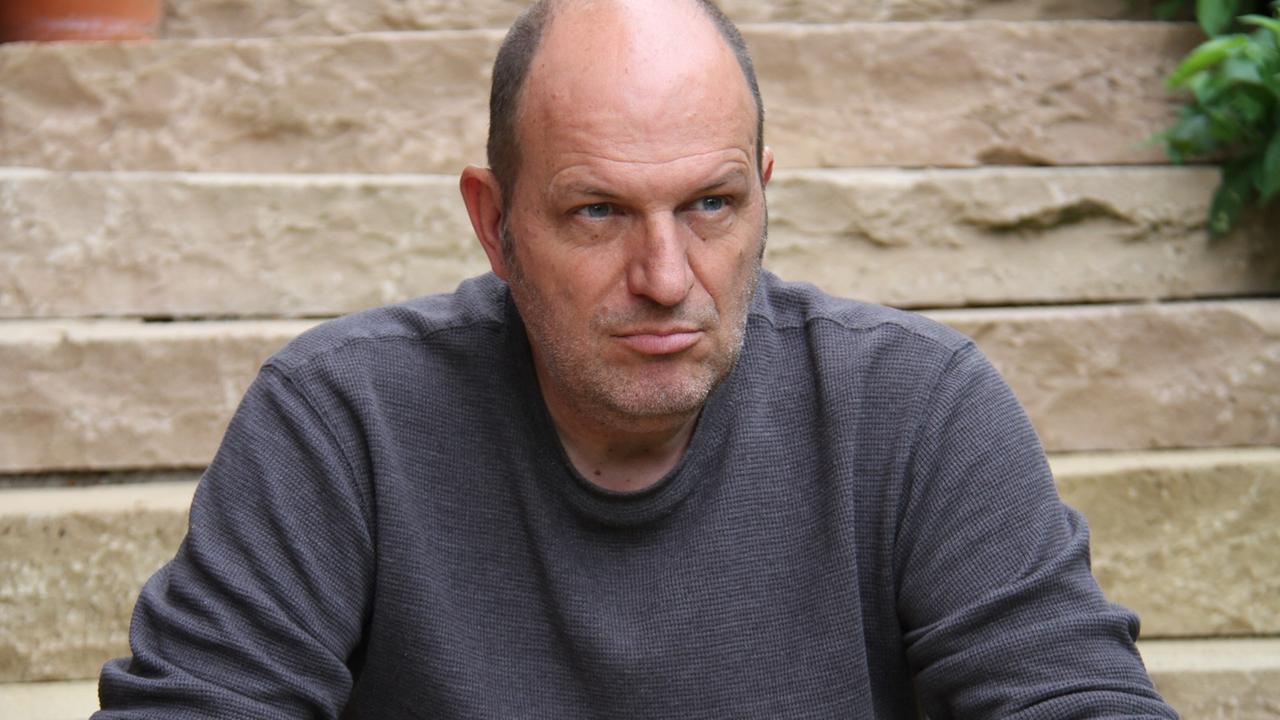 Der Kinderbuchautor Andreas Steinhöfel schaut vor einer Treppe etwas grimmig in die Ferne. Der Kinderbuchautor Andreas Steinhöfel schaut vor einer Treppe etwas grimmig in die Ferne.