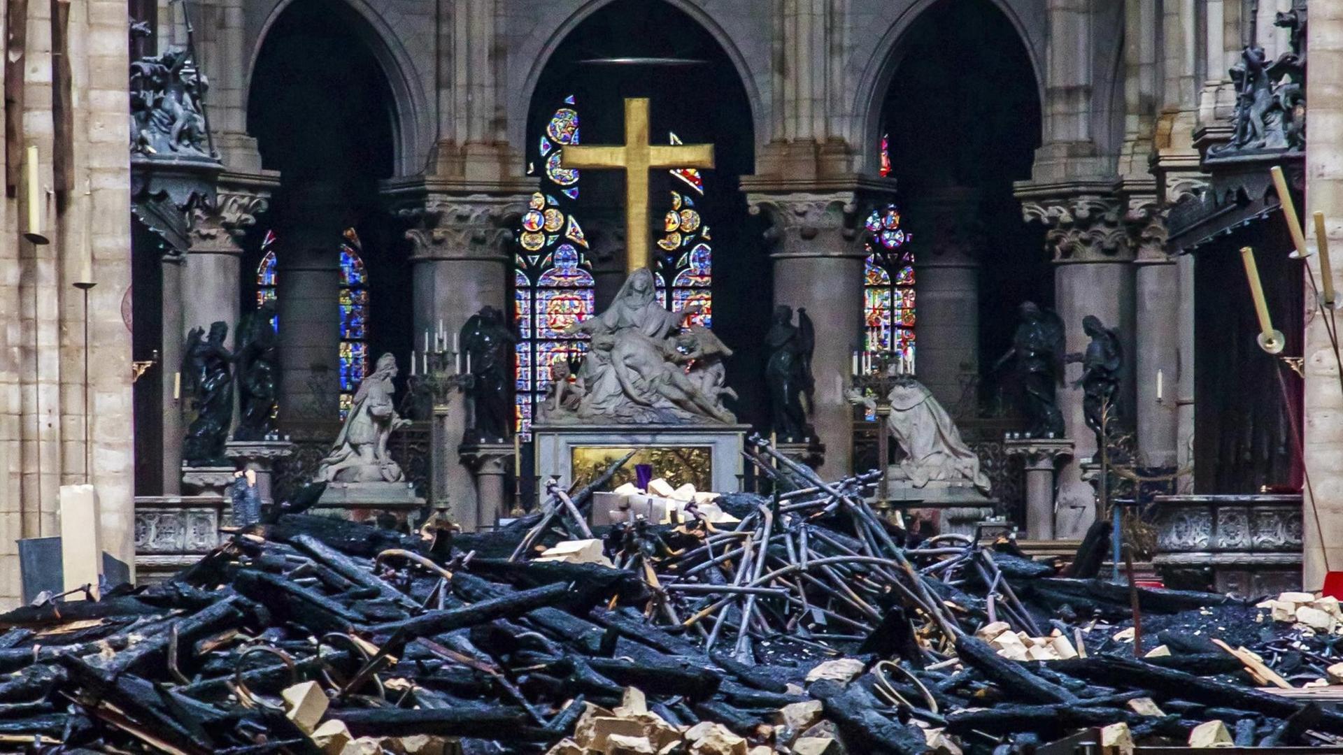 Das Innere von Notre-Dame nach dem Brand: Die Holzbalken der Dachkonstruktion liegen auf dem Boden. Das Innere von Notre-Dame nach dem Brand: Die Holzbalken der Dachkonstruktion liegen auf dem Boden.