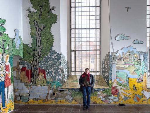 Der Maler und Grafiker Moritz Götze aus Halle/Saale vor der Schlosskirche St. Aegidien in Bernburg; Aufnahme vom März 2016