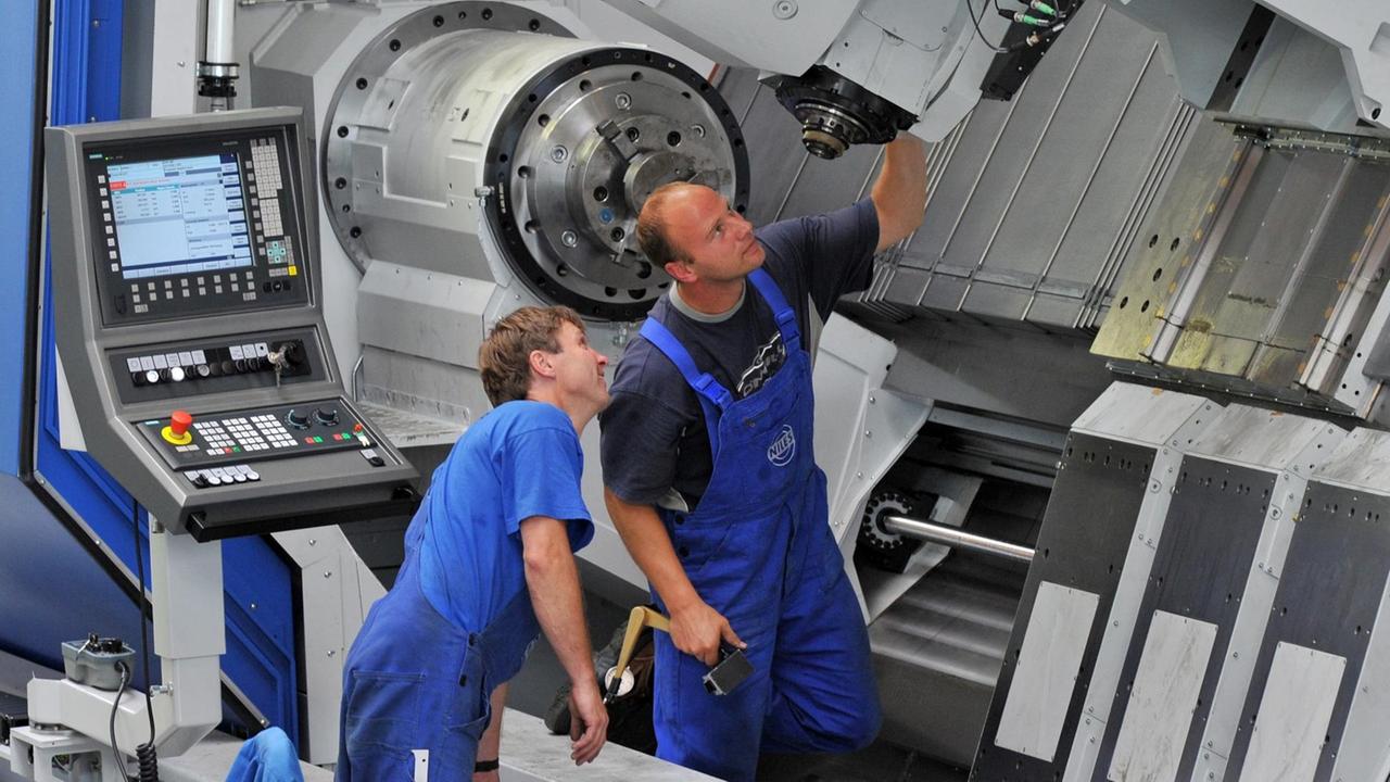 Industriemechaniker des Maschinenbauers Niles-Simmons arbeiten an einem Bearbeitungszentrum für Kurbelwellen. Industriemechaniker des Maschinenbauers Niles-Simmons arbeiten an einem Bearbeitungszentrum für Kurbelwellen.