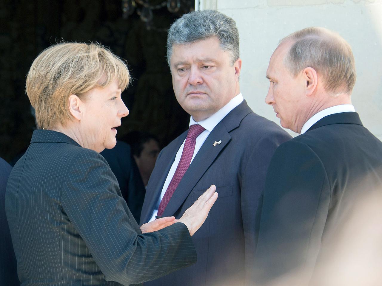 Bundeskanzlerin Merkel (CDU, l.), der designierte ukrainische Staatschef Petro Poroschenko (M) und der russische Präsident Wladimir Putin treffen sich am Rande des Festakts zum 70. Jahrestag der Truppenlandung der Alliierten in der Normandie.
