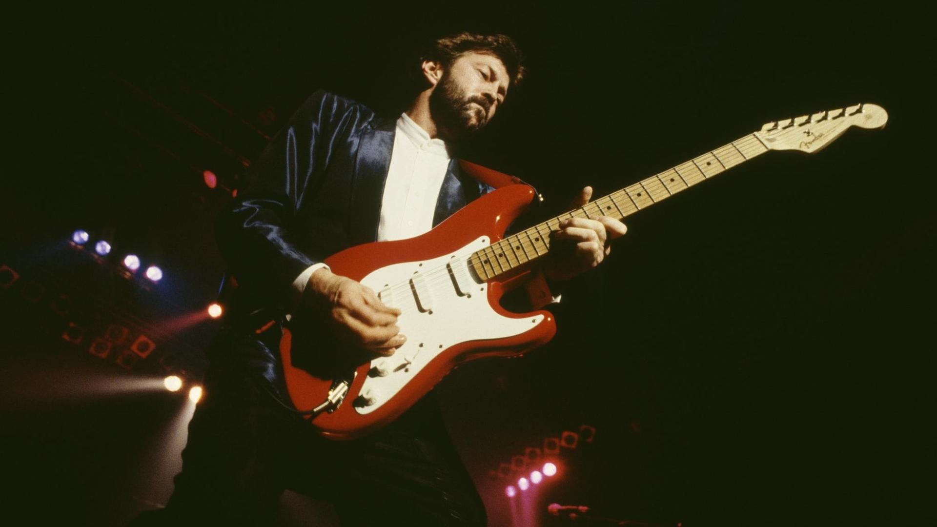 Eric Clapton mit seiner Fender Stratocaster Gitarre auf der Bühne in Rom 1986. Eric Clapton mit seiner Fender Stratocaster Gitarre auf der Bühne in Rom 1986.