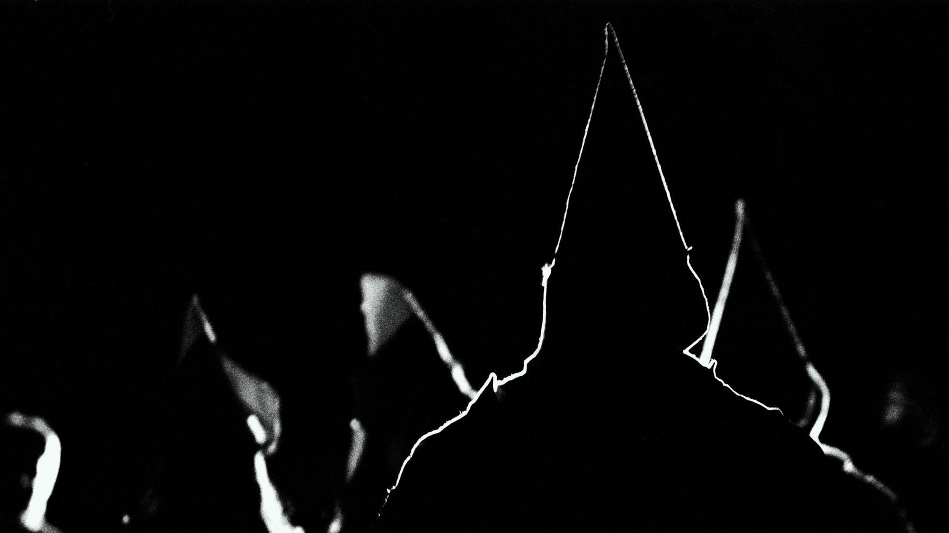 Silhouetten von spitzen Kapuzen der Ku Klux Klan Anhänger.