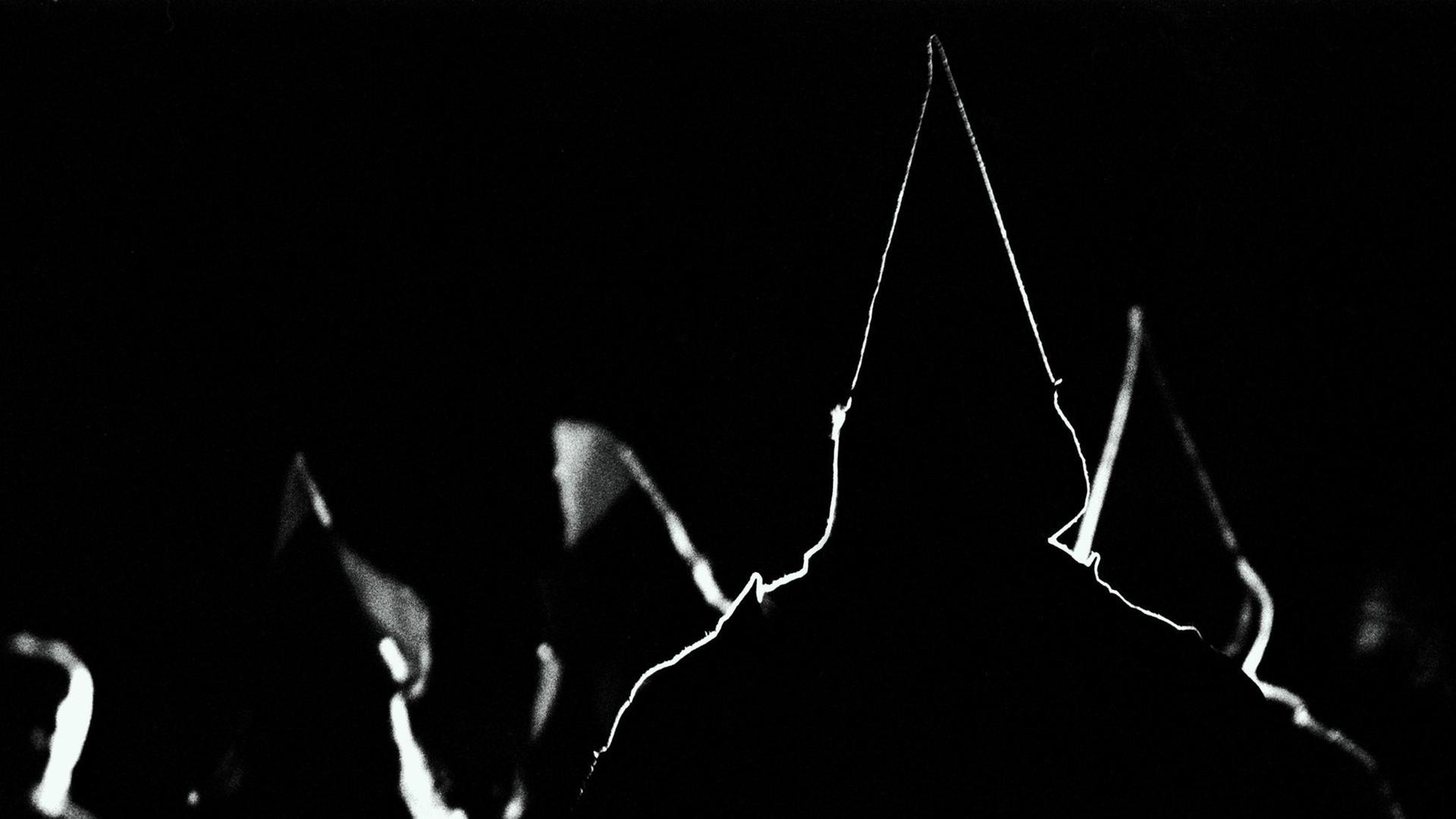 Silhouetten von spitzen Kapuzen der Ku Klux Klan Anhänger. Silhouetten von spitzen Kapuzen der Ku Klux Klan Anhänger.