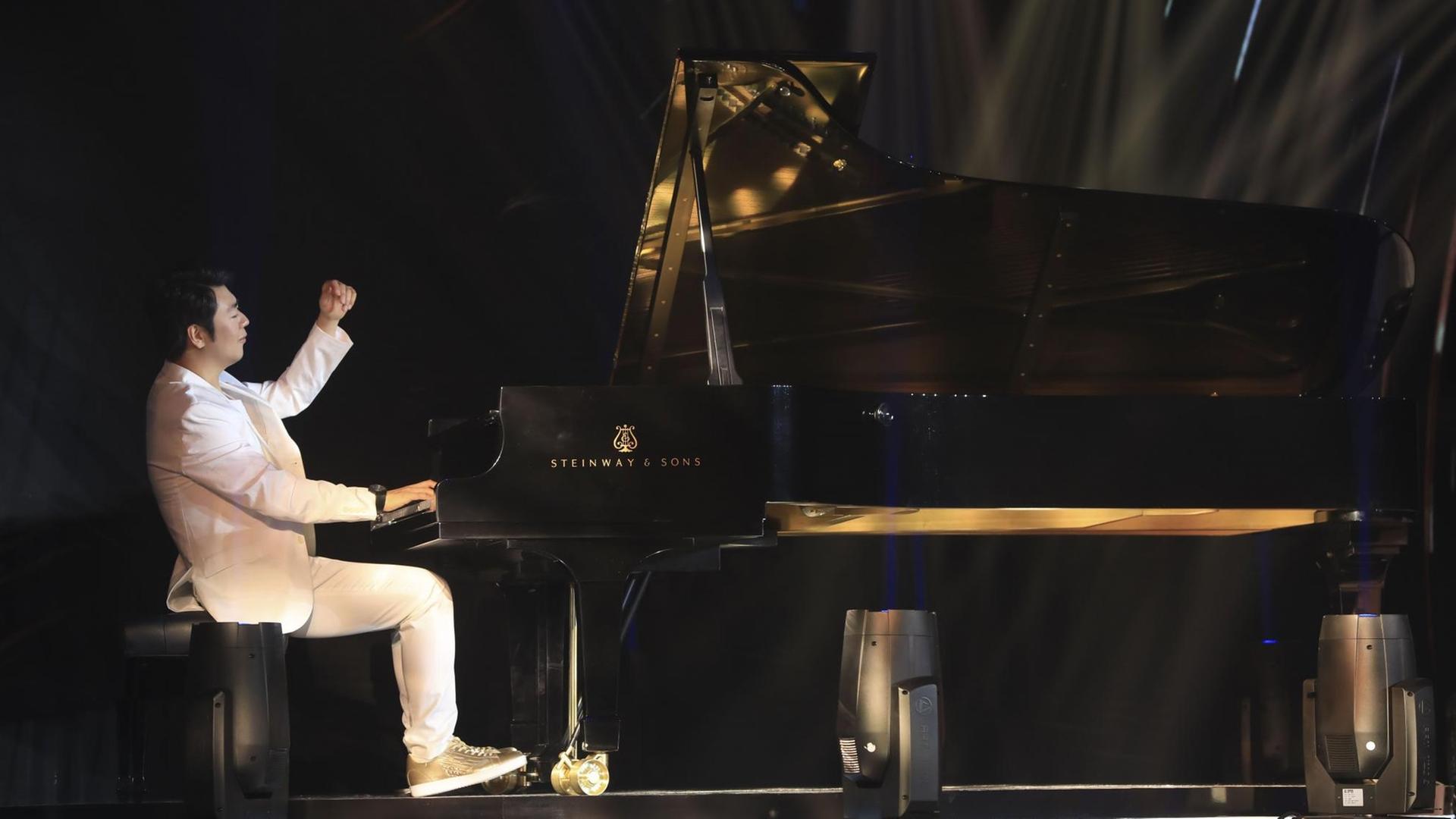 Ein Pianist spielt in weißem Anzug und goldenen Sneakers an einem Steinway-Flügel.