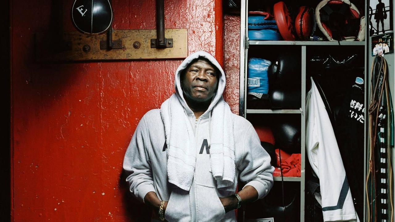 Filmszene aus dem Dokumentarfilm "Ring of Fire: Die Emile Griffith Story". Griffith steht vor einem Spint in einem Boxstall. Filmszene aus dem Dokumentarfilm "Ring of Fire: Die Emile Griffith Story". Griffith steht vor einem Spint in einem Boxstall.