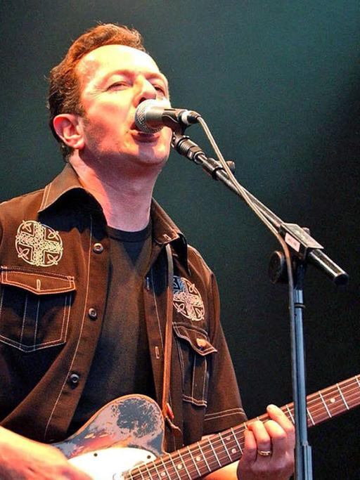 Joe Strummer, Veteran des britischen Polit-Punk, aufgenommen bei einem Konzert am 8.6.2002 in London. Der Sänger und Gitarrist der Punk-Band The Clash, \fs12\ \fs16\der mit bürgerlichem Namen John Graham Mellor hieß, starb im Alter von nur 50 Jahren nach Mitteilung der Polizei am 23.12.2002 «plötzlich und unerwartet» in seinem Farmhaus in Somerset (Westengland). The Clash war 1979 mit der Single «London Calling» weltweit berühmt geworden. Die Band gab der Punk-Bewegung der 70er Jahre einen starken politischen Einschlag. Ihre Mitglieder wurden in Großbritannien häufig als «Rebellen mit politischem Engagament» bezeichnet.