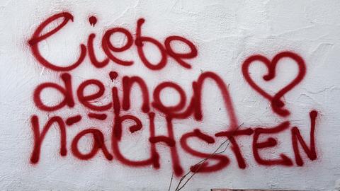 Ein Graffiti mit der Aufschrift "liebe deinen nächsten"