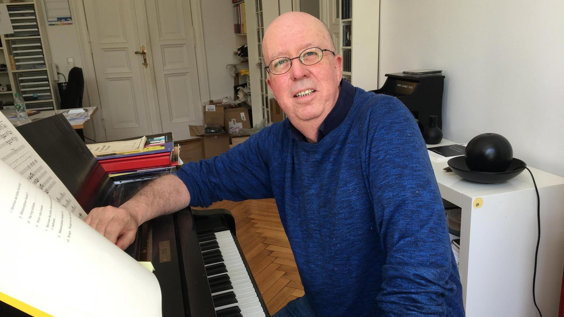 Hans Rotman sitzt am Klavier und schaut in die Kamera Hans Rotman sitzt am Klavier und schaut in die Kamera