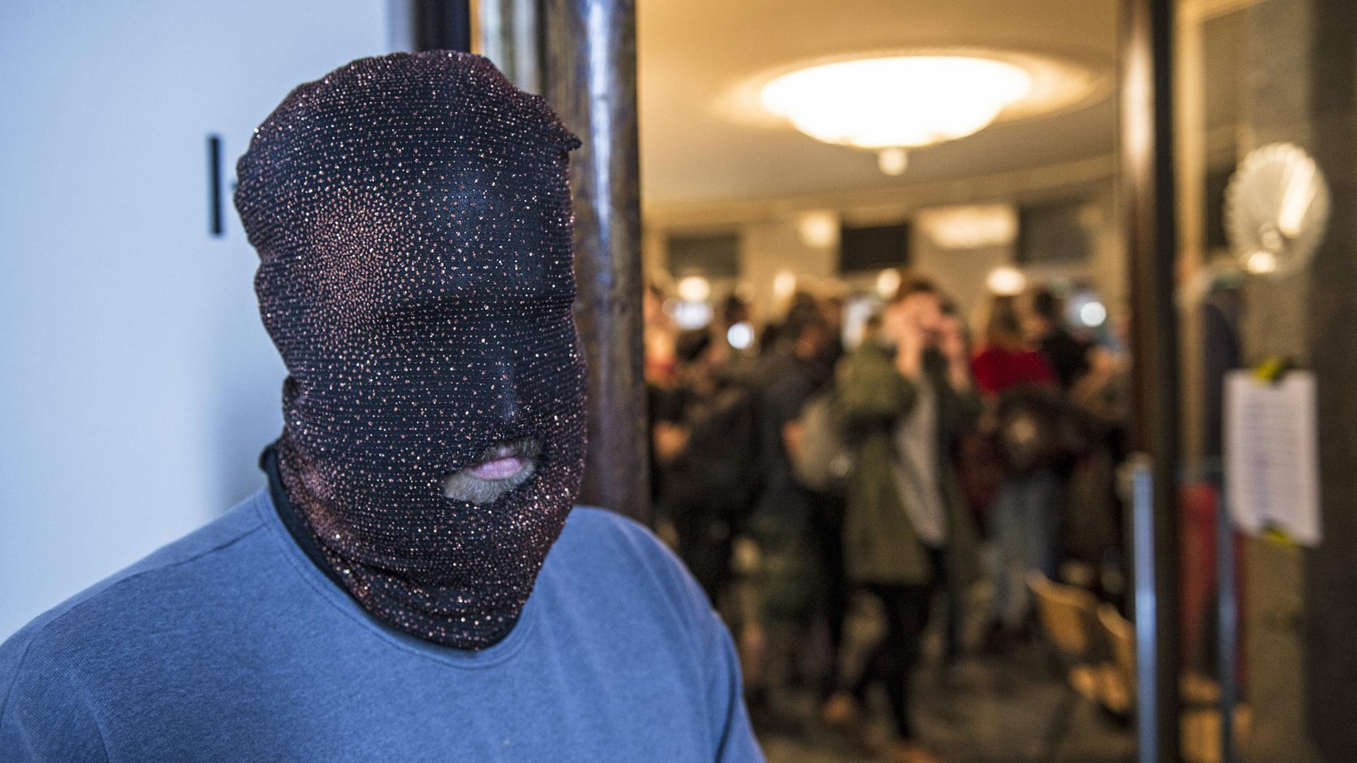 Ein Aktivist mit Maske steht in Berlin im Foyer der Volksbühne. Aktivisten haben das Gebäude besetzt.