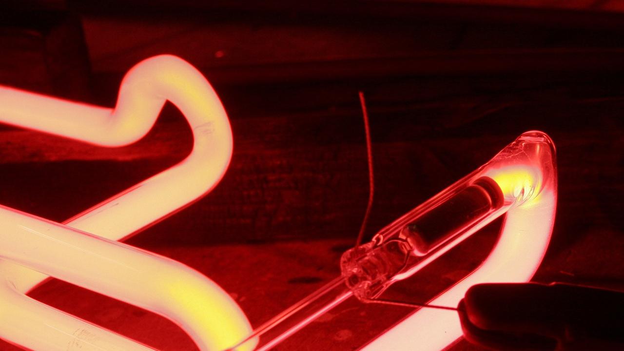 In eine Glasröhre für eine Leuchtreklame wird Neonleuchtstoff eingebrannt. In eine Glasröhre für eine Leuchtreklame wird Neonleuchtstoff eingebrannt.