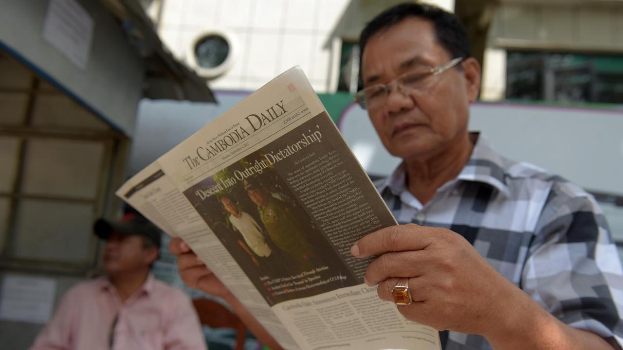 Ein Mann in Phnom Penh liest die letzte Ausgabe der Zeitung "The Cambodia Daily".