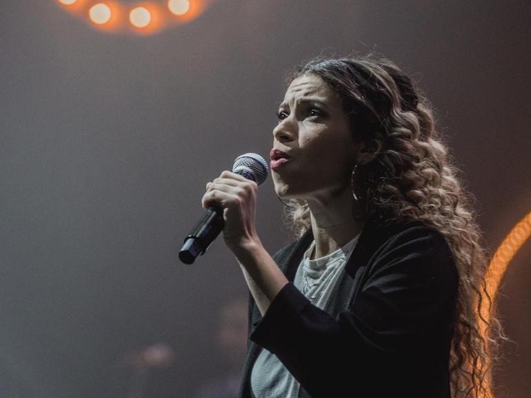 Eine Frau singt während eines Konzerts.