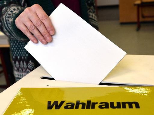 Eine Frau steckt am 13.03.2016 in einem Wahllokal in Ludwigsburg (Baden-Württemberg) ihren Stimmzettel für die Landtagswahl in Baden-Württemberg in eine Wahlurne