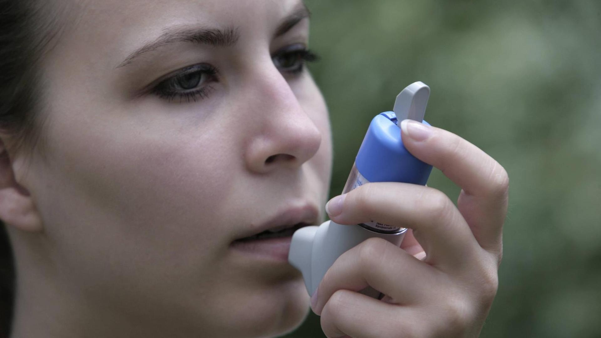 Frau mit einem Inhalator für Asthmaspray.
