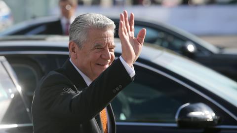 Bundespräsident Joachim Gauck winkt in die Menge bei seiner Ankunft in Leipzig zum Festakt zur Friedlichen Revolution.