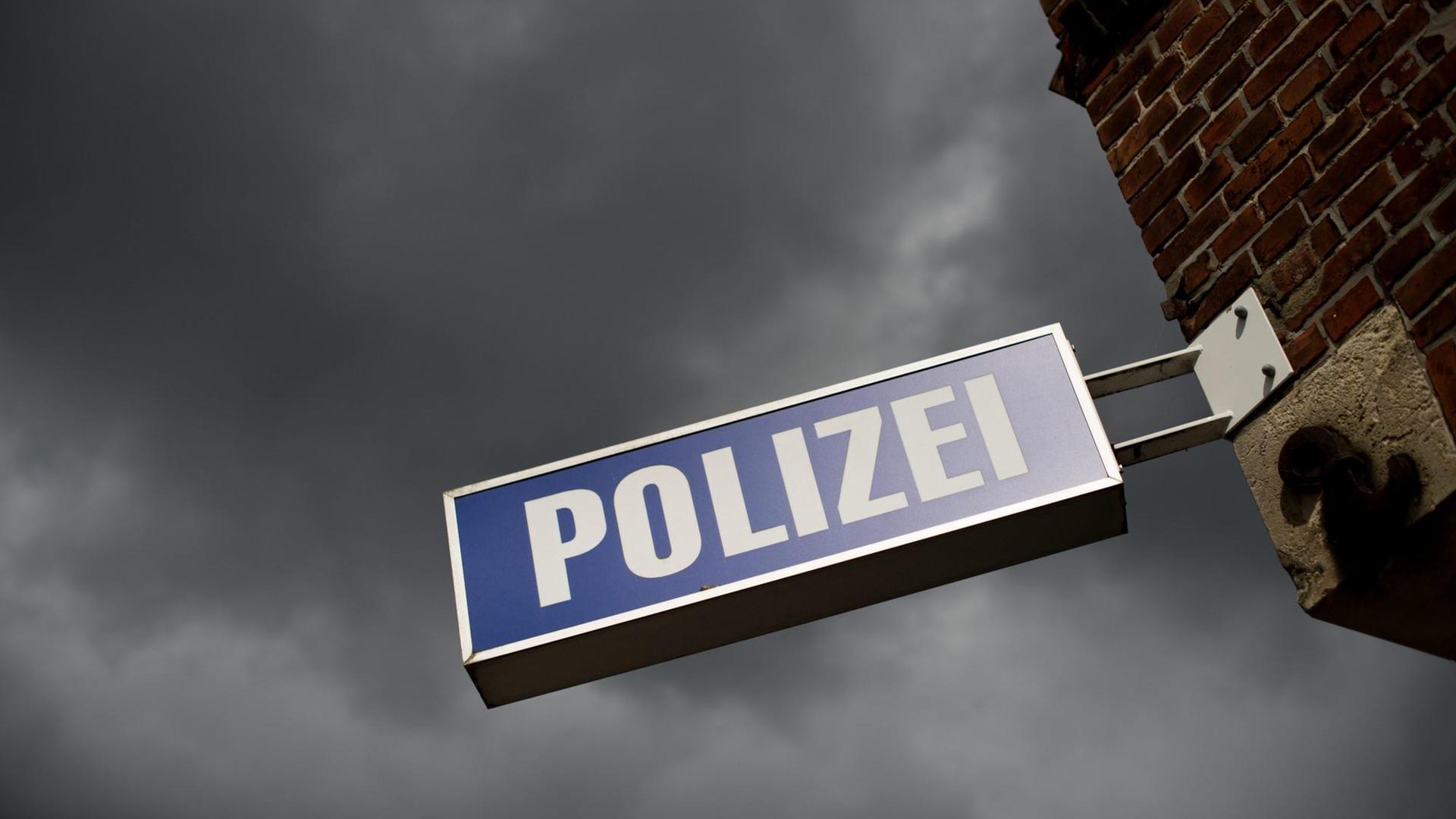 Ein Polizeischild vor einem Himmel mit dunklen Wolken. Ein Polizeischild vor einem Himmel mit dunklen Wolken.