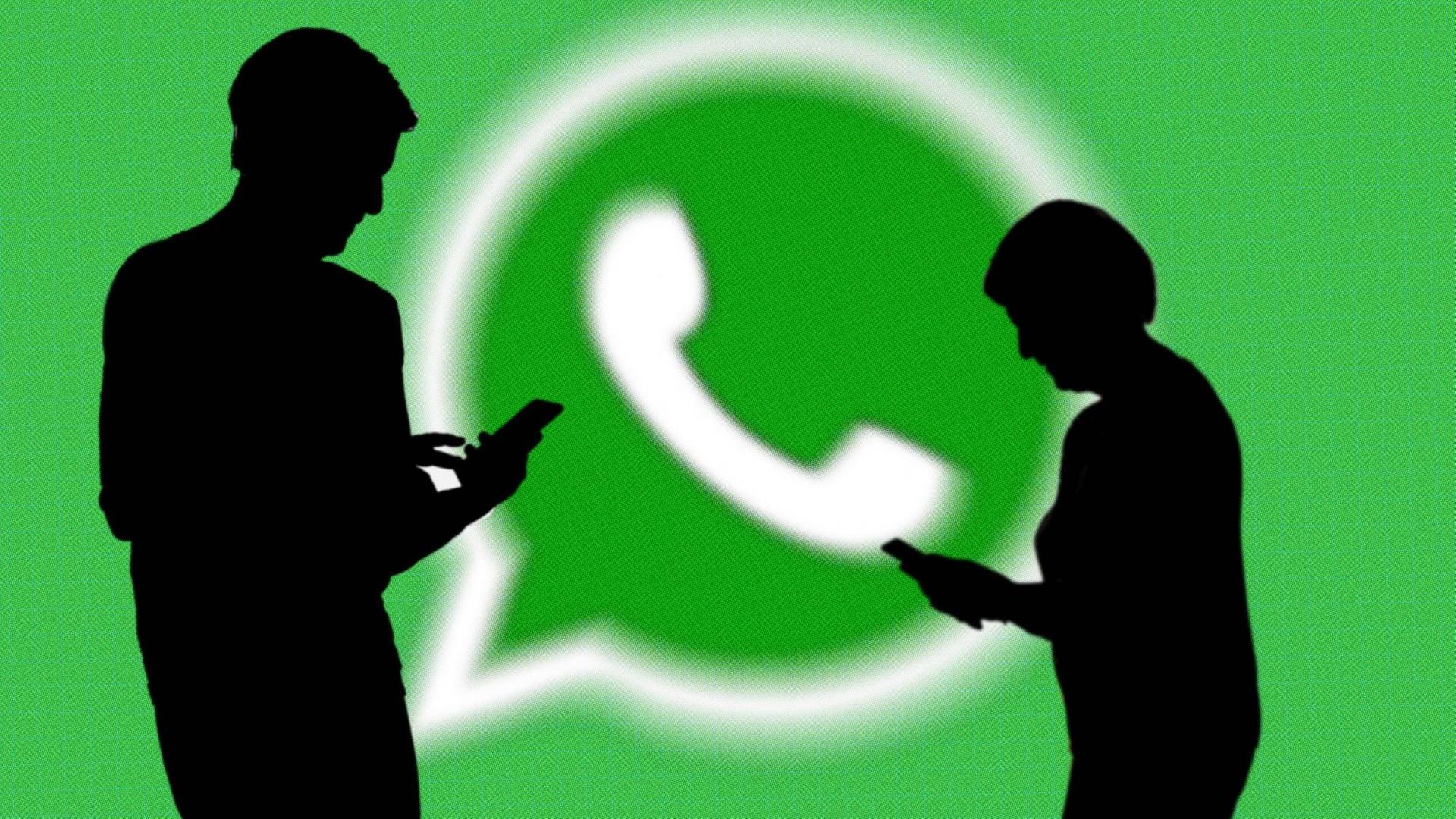 Das Logo von WhatsApp, vor dem die Silhouetten von zwei Personen zu sehen sind. Das Logo von WhatsApp, vor dem die Silhouetten von zwei Personen zu sehen sind.