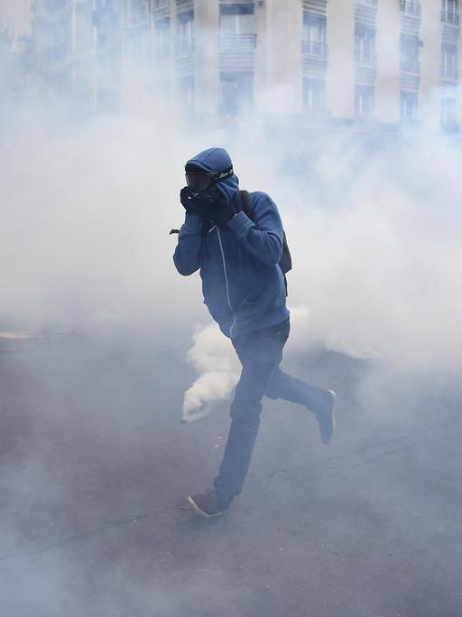 Ein Demonstrant rennt durch eine Wolke von Tränengas.