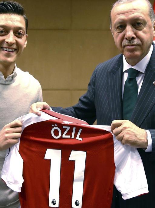 Özil und Erdogan halten ein Trikot des Fußballspielers in den Händen.