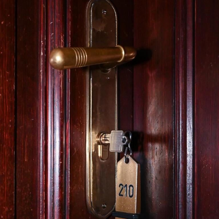 Ein Schlüssel steckt im Schloss zu einem Hotelzimmer