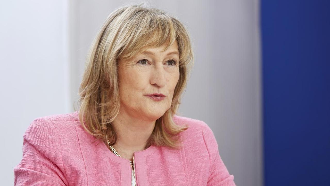 Manuela Rousseau sitzt an einem Tisch und guckt an der Kamera vorbei. Manuela Rousseau sitzt an einem Tisch und guckt an der Kamera vorbei.