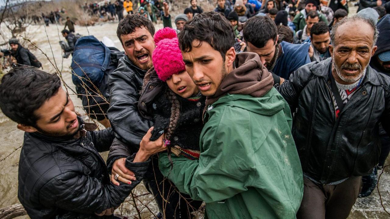 Flüchtlinge beim Versuch, einen Fluss bei Idomeni zu überqueren Flüchtlinge beim Versuch, einen Fluss bei Idomeni zu überqueren