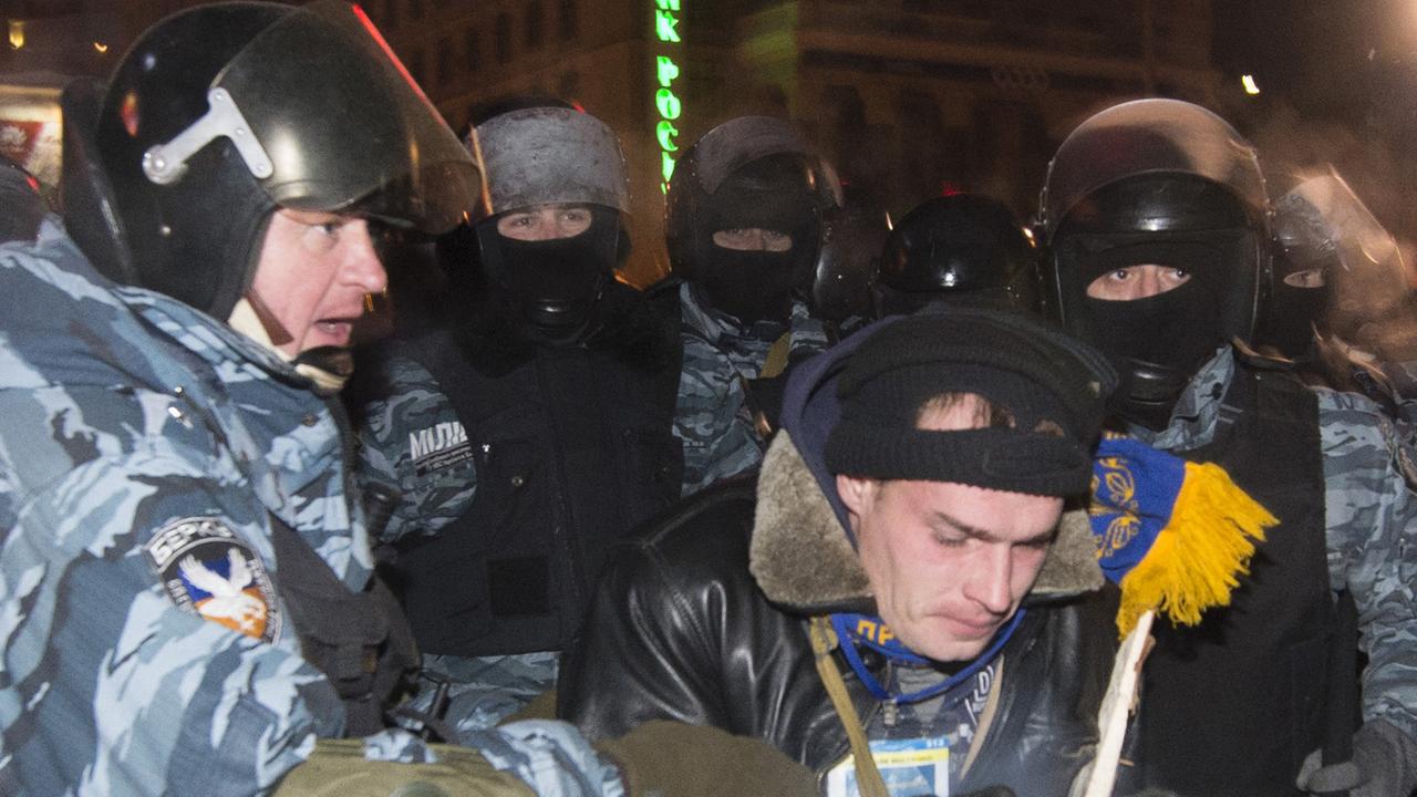 Polizisten mit einem Demonstrenten am 11. Dezember 2013 in Kiew Polizisten mit einem Demonstrenten am 11. Dezember 2013 in Kiew