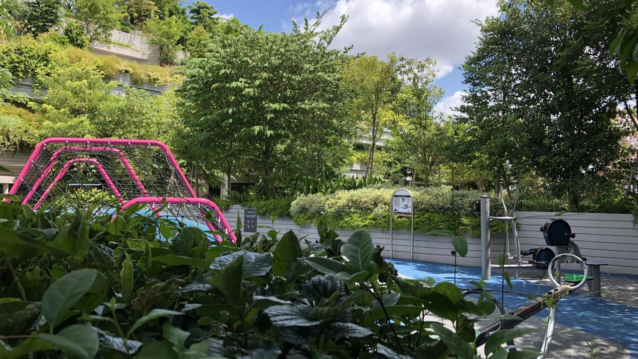 Spielplatz mit Sportgeräten und viel Grün in einem Wohnkomplex Spielplatz mit Sportgeräten und viel Grün in einem Wohnkomplex