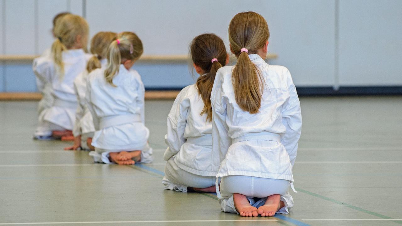 Junge Mädchen knien während einer Trainingsstunde im Karate. Viele Eltern, besonders die kleiner Mädchen legen großen Wert darauf, dass ihre Kinder schon früh lernen, wie sie sich effektiv verteidigen können. Foto: Hans-Jürgen Wiedl/dpa-Zentralbild/ZB