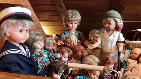 Die Puppen des Müllmuseum Wallbach sitzen nebeneinander.