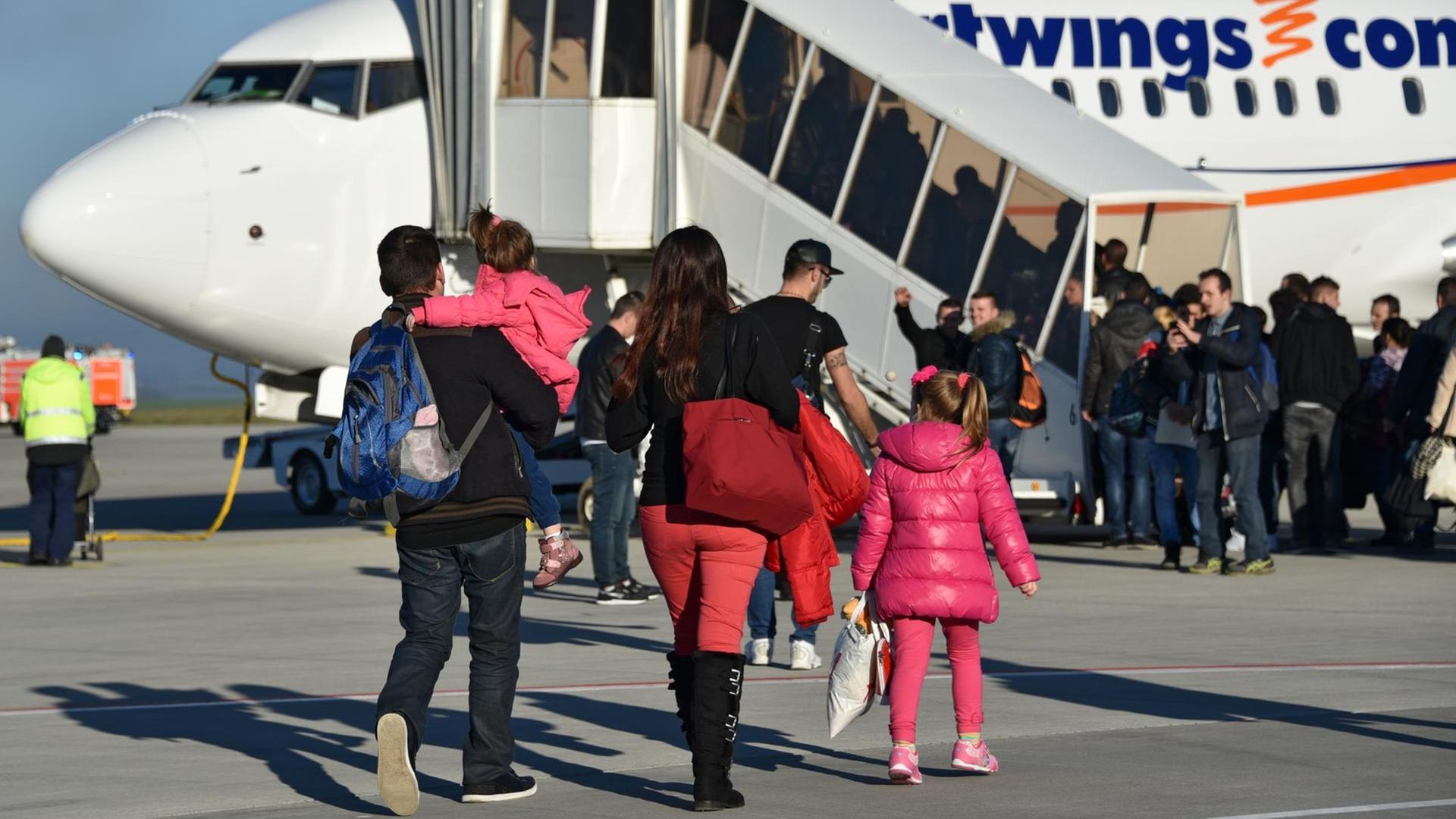 Abgelehnte Asylbewerber aus Albanien und dem Kosovo gehen am 27.11.2015 auf dem Kassel-Airport in Calden (Hessen) zum Flieger. Die sogenannte freiwillige Ausreise führt sie zurück nach Pristina (Kosovo) und Tirana (Albanien). Foto: Uwe Zucchi /dpa (zu lhe-Reportage "Einmal Traum und zurück - Wenn Asylsuchende per Flieger zurückreisen" vom 02.12.2015) | Verwendung weltweit Abgelehnte Asylbewerber aus Albanien und dem Kosovo gehen am 27.11.2015 auf dem Kassel-Airport in Calden (Hessen) zum Flieger. Die sogenannte freiwillige Ausreise führt sie zurück nach Pristina (Kosovo) und Tirana (Albanien). Foto: Uwe Zucchi /dpa (zu lhe-Reportage "Einmal Traum und zurück - Wenn Asylsuchende per Flieger zurückreisen" vom 02.12.2015) | Verwendung weltweit