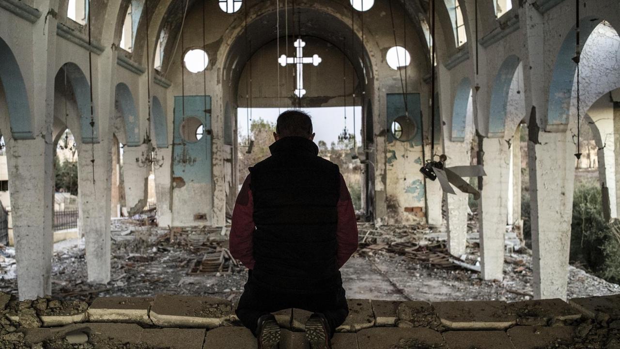 Ein Bewohner der Provinz Al-Hasake in Syrien betet in einer Kirche, die vom Islamischen Staat zerstört wurde.