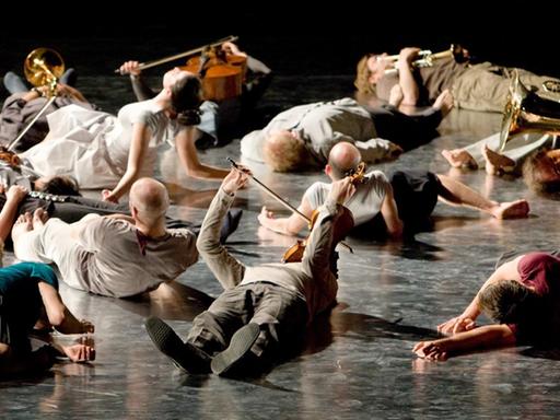 ARCHIV - Mitglieder des Ensemble Modern liegen während der Uraufführung von Wolfgang Rihms "Jagden und Formen (Zustand 2008)" auf der Bühne.