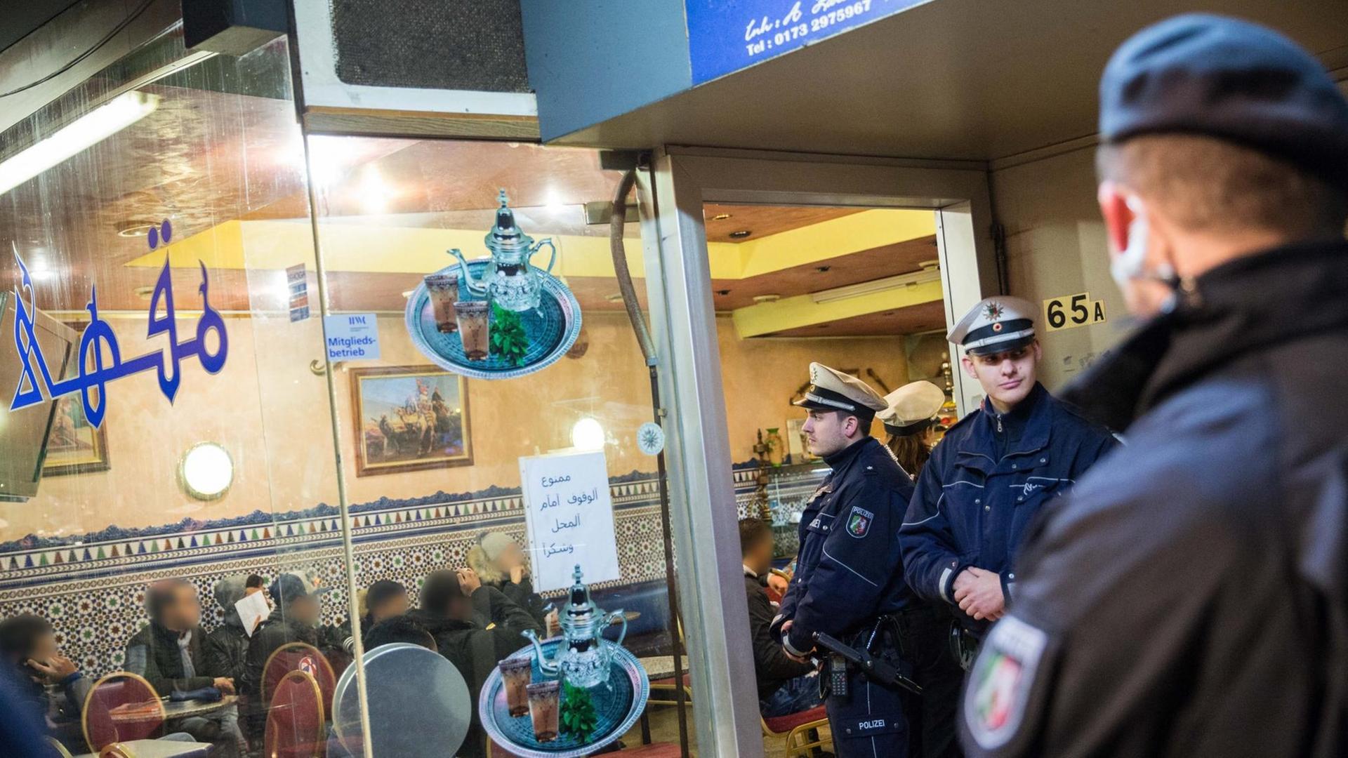 Polizei steht vor einem Café im Nordafrikaner-Viertel von Düsseldorf während einer Razzia. 