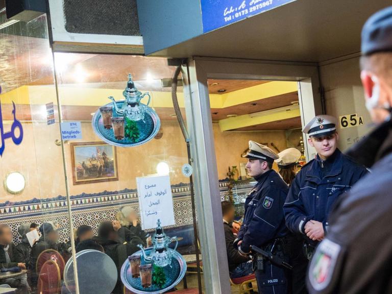 Polizei steht vor einem Cafe am 16.01.2016 im Nordafrikaner-Viertel von Düsseldorf (Nordrhein-Westfalen) während eine Razzia. Mit mehreren Hundert Beamten ist die Polizei zu einer Razzia in das sogenannte Maghreb-Viertel eingerückt.