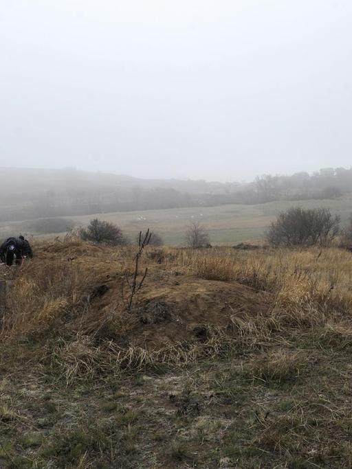 Ukrainische Sicherheitskräfte beobachten Aktivisten, die Gräben nahe des Asowschen Meers graben.