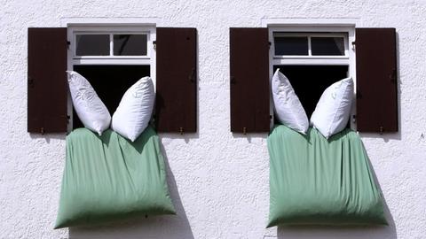 Aus einem offenen Fenster hängt Bettwäsche zum Auslüften.