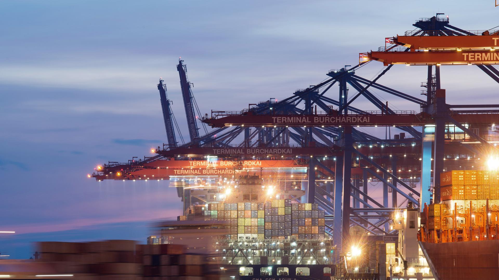 Containerschiffe liegen kurz nach Sonnenuntergang im Hafen in Hamburg am Terminal Burchardkai. Containerschiffe liegen kurz nach Sonnenuntergang im Hafen in Hamburg am Terminal Burchardkai.