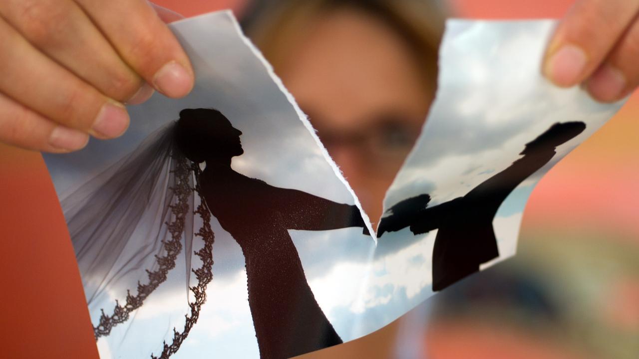 Eine Frau zereisst ihr Hochzeitsfoto. Eine Frau zereisst ihr Hochzeitsfoto.