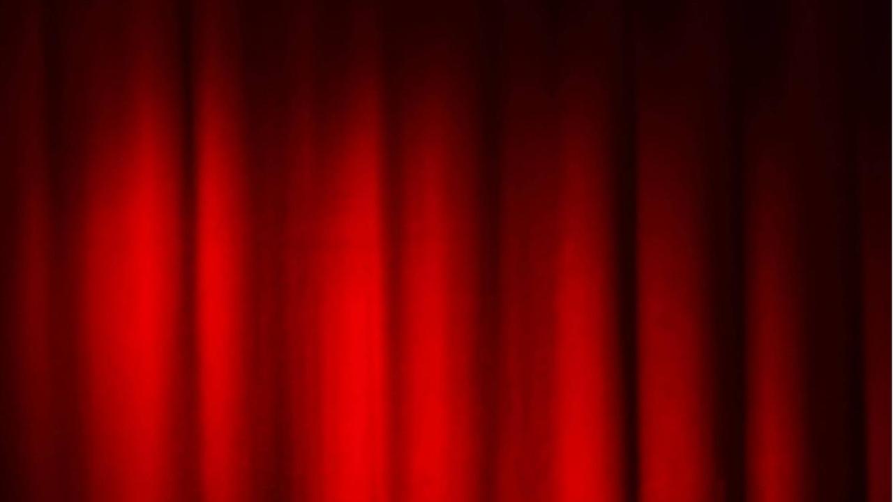 Ein Spot ist auf einen roten Bühnenvorhang gerichtet. Ein Spot ist auf einen roten Bühnenvorhang gerichtet.