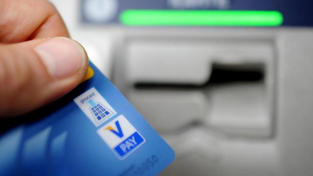 Ein Bankkunde hebt in Hamburg mit seiner Girokarte Bargeld von einem Geldautomaten ab.