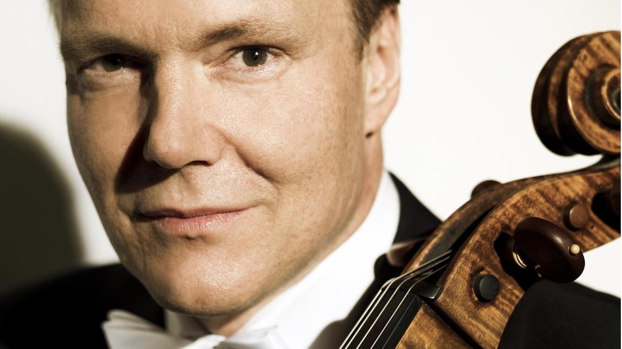 Das Cello des Musikers liegt an der Schulter an, während Mørk in Konzertkleidung leise in die Kamera lächelt. Das Cello des Musikers liegt an der Schulter an, während Mørk in Konzertkleidung leise in die Kamera lächelt.