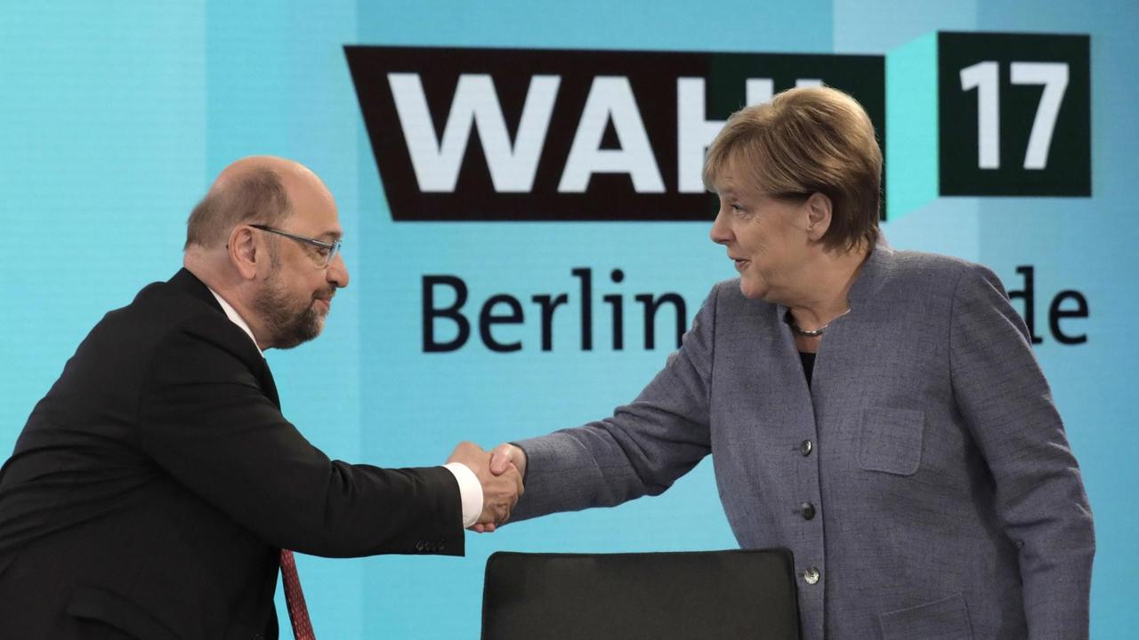 Bundeskanzlerin Angela Merkel (CDU) gibt dem SPD-Vorsitzenden Martin Schulz am 24.09.2017 in Berlin vor einer Fernsehrunde der Parteivorsitzenden nach der Bundestagswahl die Hand. Bundeskanzlerin Angela Merkel (CDU) gibt dem SPD-Vorsitzenden Martin Schulz am 24.09.2017 in Berlin vor einer Fernsehrunde der Parteivorsitzenden nach der Bundestagswahl die Hand.