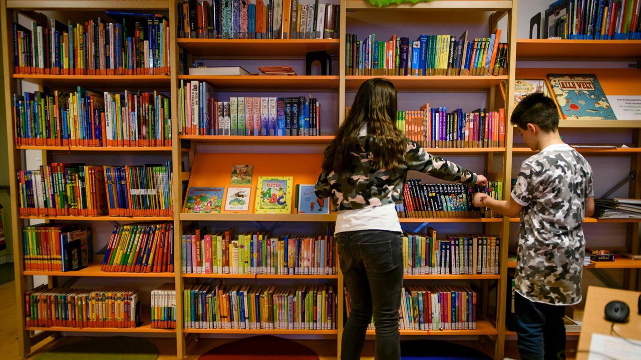 Miray (l) und Denizcan durchsuchen am 14.03.2017 in der Kinderbibliothek im Zukunftshaus Wedding im Paul Gerhardt Stift in Berlin ein Bücherregal nach ihren Lieblingsbüchern. Miray (l) und Denizcan durchsuchen am 14.03.2017 in der Kinderbibliothek im Zukunftshaus Wedding im Paul Gerhardt Stift in Berlin ein Bücherregal nach ihren Lieblingsbüchern.