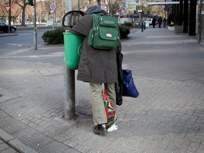 Ein Mann sucht in der Düsseldorfer Innenstadt in einem Mülleimer nach verwertbarem Material.