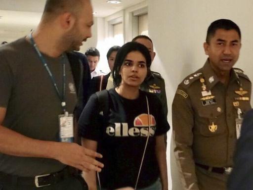 Rahaf Mohammed al-Kunun (M), die aus Saudi-Arabien geflohen ist, neben Surachate Hakparn (r), Chef der Einwanderungspolizei von Thailand, am internationalen Flughafen in Bangkok.
