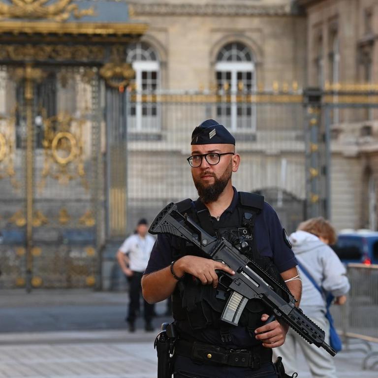 Ein schwer bewaffneter Polizist bewacht den Eingang zum Palais de Justice in Paris.